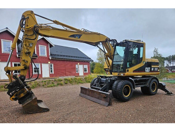 Grävmaskin på däck Caterpillar M312 Engcon EC20 tiltrotator