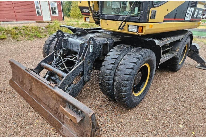 Grävmaskin på däck Caterpillar M312 Engcon EC20 tiltrotator