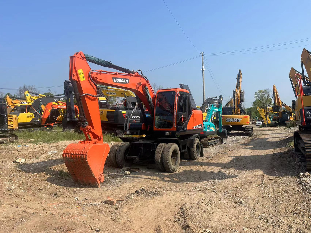 Doosan DX150W-9C - Grävmaskin på däck: bild 1 Doosan DX150W-9C - Grävmaskin på däck: bild 1