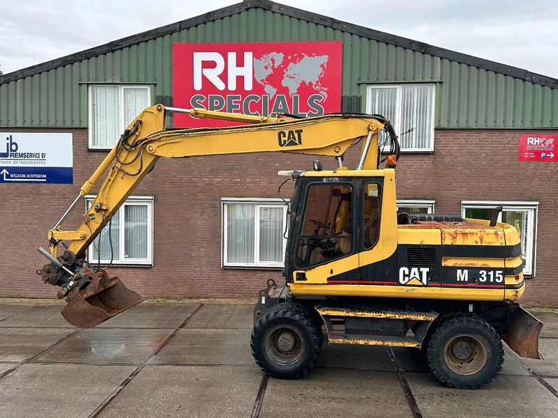 Caterpillar M315 +ROTO CE - Grävmaskin på däck: bild 1 Caterpillar M315 +ROTO CE - Grävmaskin på däck: bild 1